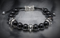 Black sardonyx bead bracelet with silver decorative spacers, a slider charm featuring 'WH' logo, and black braided cord.