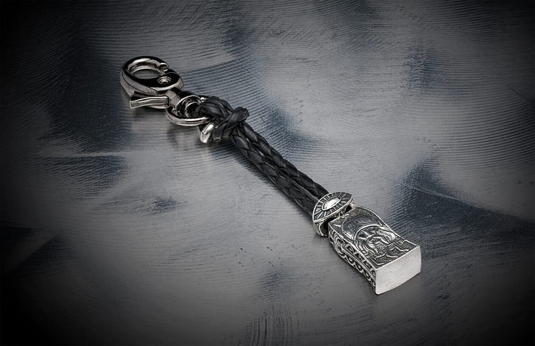 Silver-toned key chain with braided black leather by Touchstone, featuring an ornate warrior head charm and a carabiner clasp.