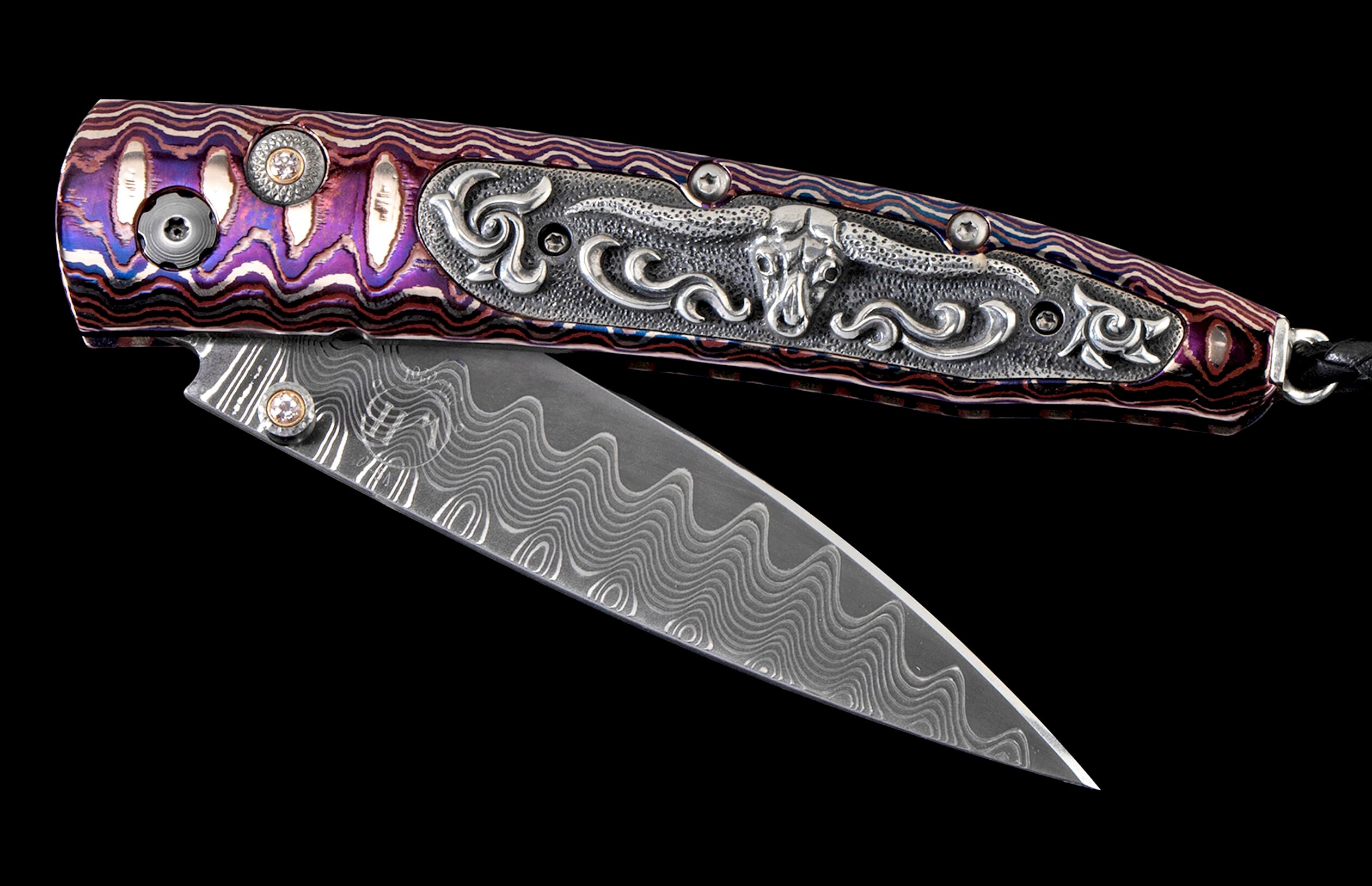 Decorative folding knife with a purple, blue, and red wavy patterned handle, intricate silver metalwork featuring a bull skull, and a wavy Damascus steel blade.