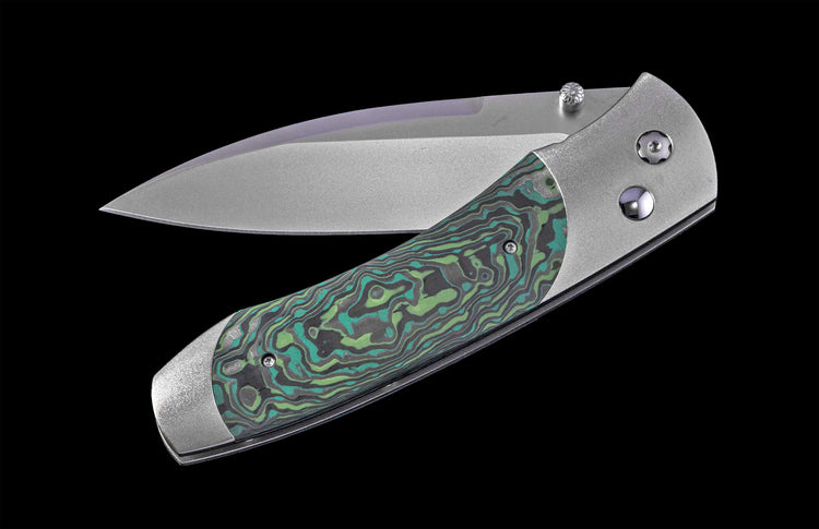 A folding knife with a matte silver blade and a green, teal, and gray swirled handle, partially open on black.