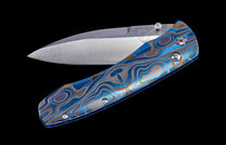 Folding knife with anodized and color-laser engraved frame on a black background