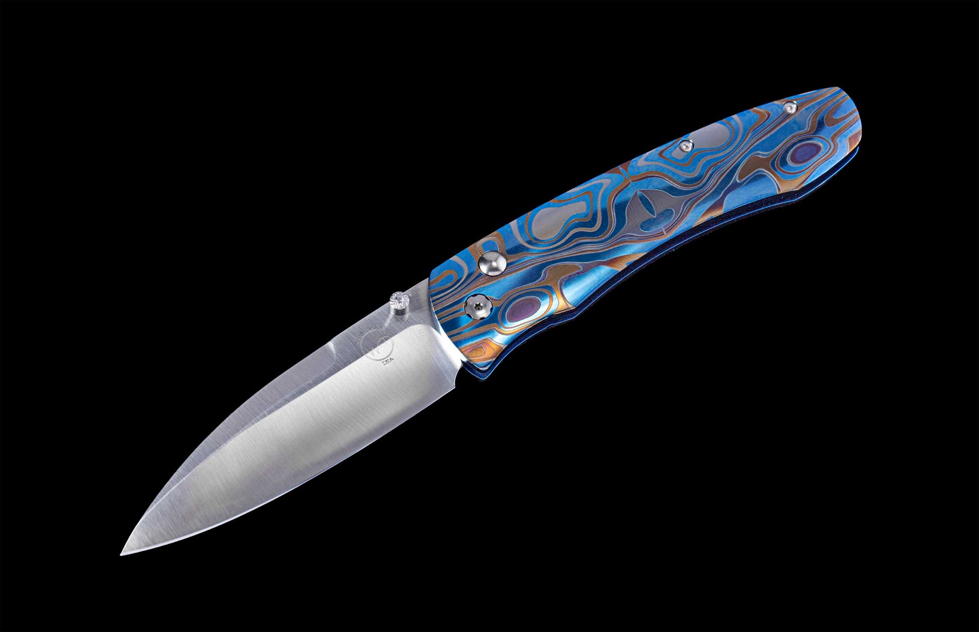Folding knife with anodized and color-laser engraved frame on a black background