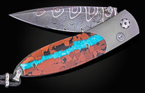 William Henry knife inlaid with vein turquoise and lava rock with damascus blade.