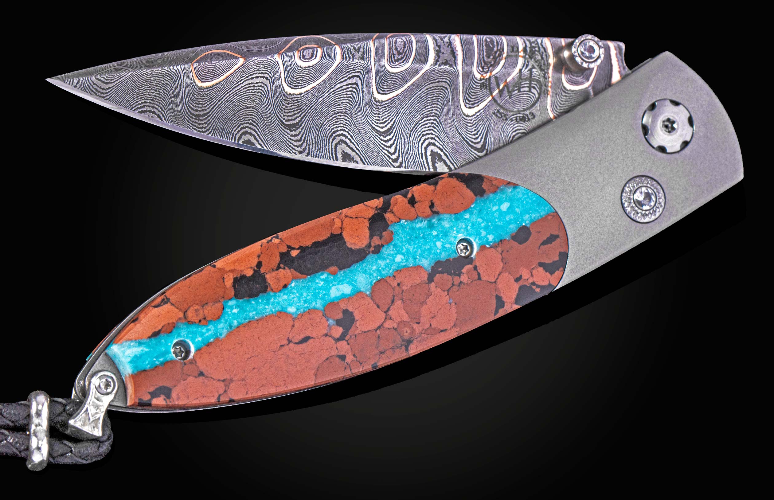William Henry knife inlaid with vein turquoise and lava rock with damascus blade.