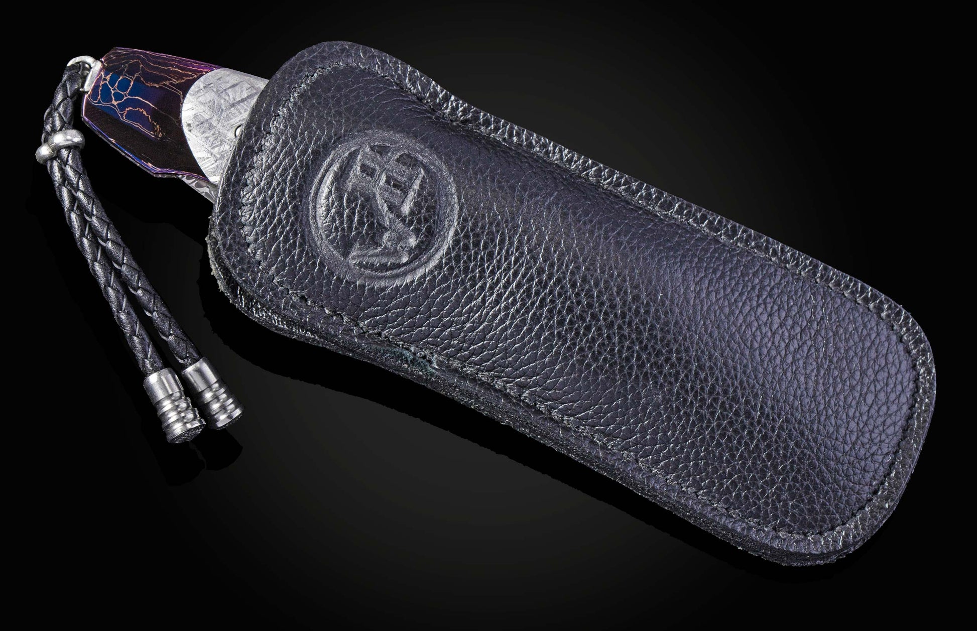 William Henry knife with a colorful handle and engraved blade on a black background