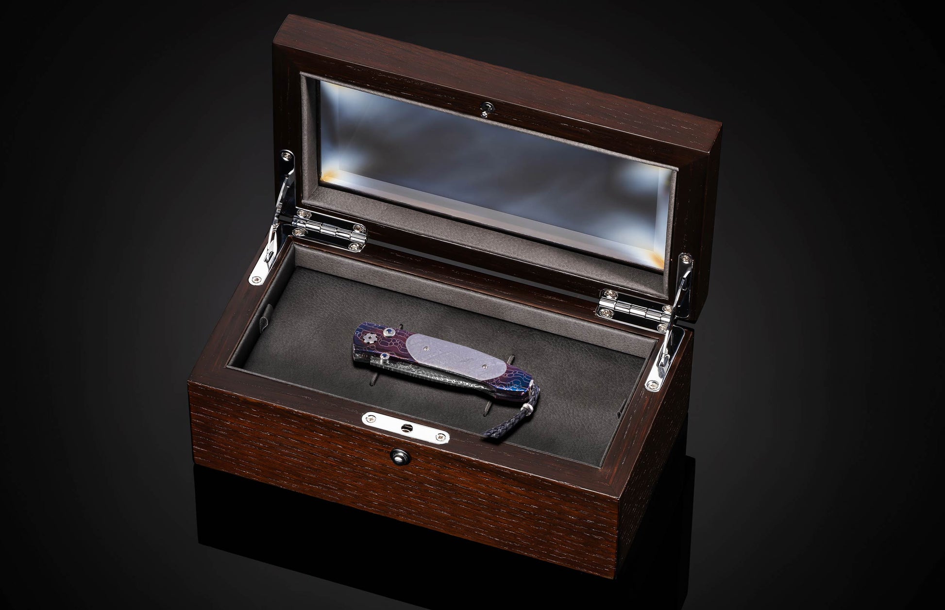 William Henry knife with a colorful handle and engraved blade on a black background