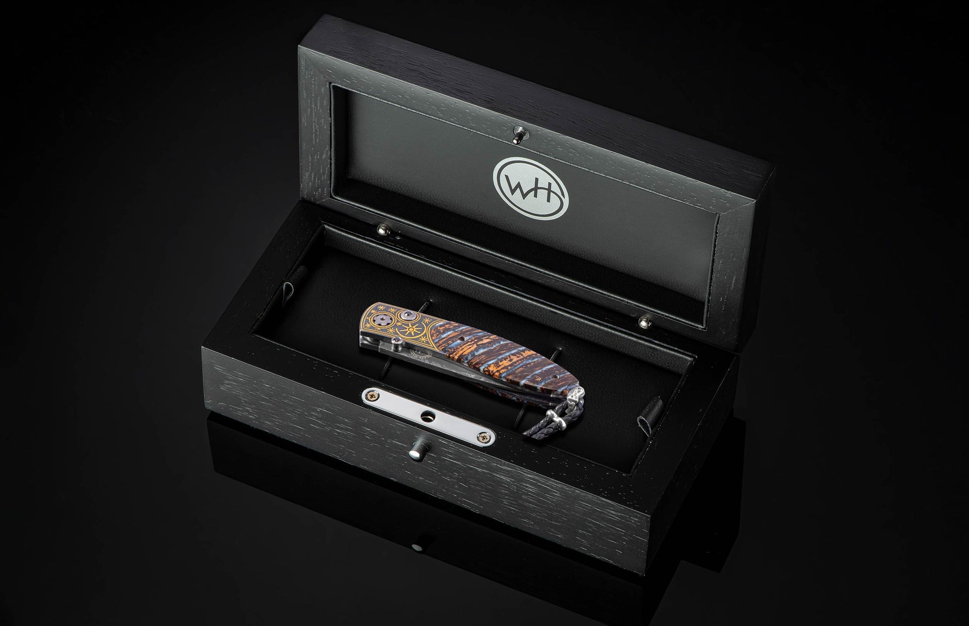 Black open box with a knife inside on a black background