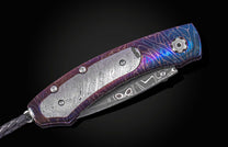 Folding knife with decorative handle and blade on a black background