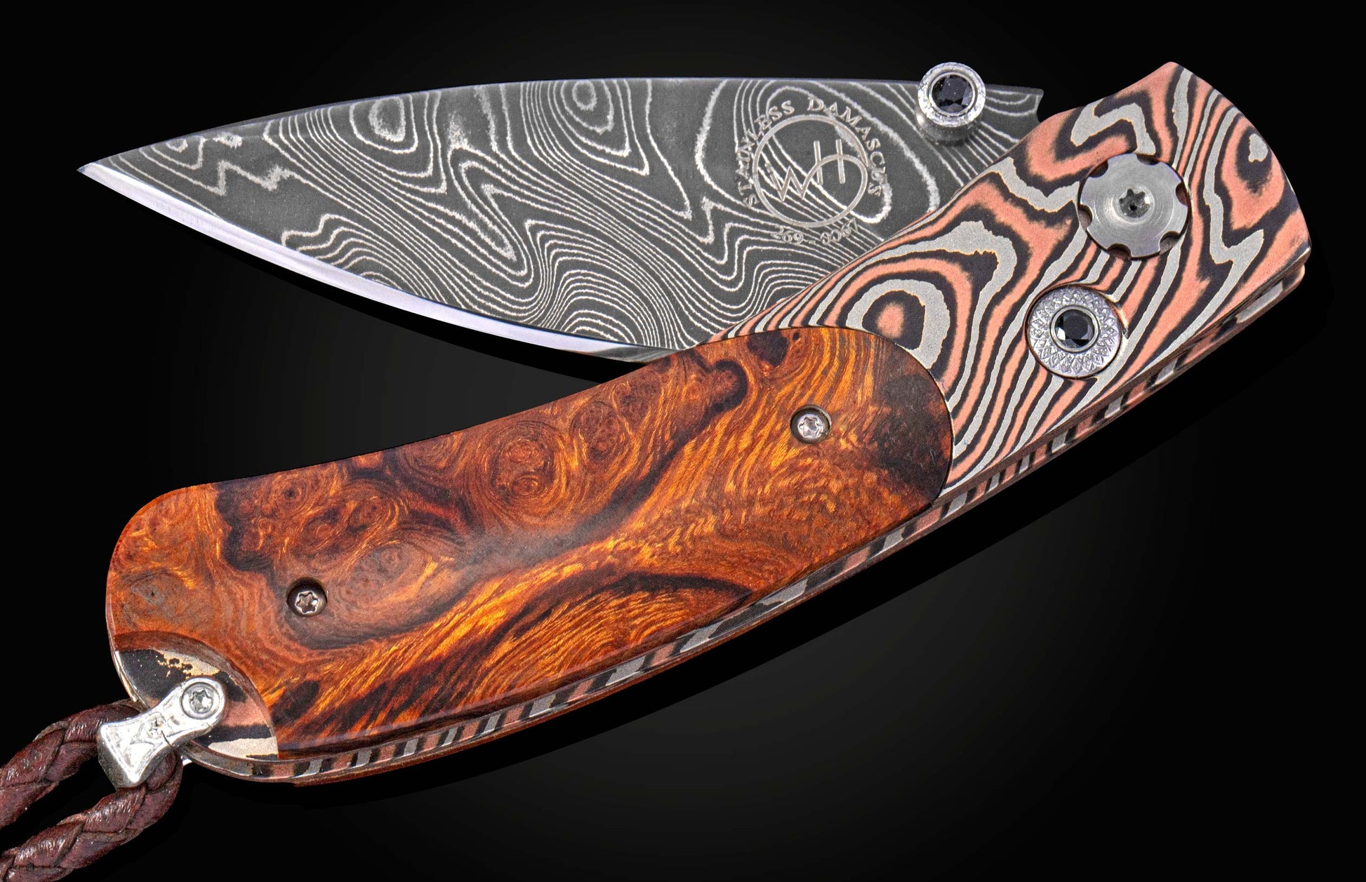 Folding knife with a wavy Damascus steel blade and a patterned handle of burl wood and copper-striped metal, with a leather lanyard.