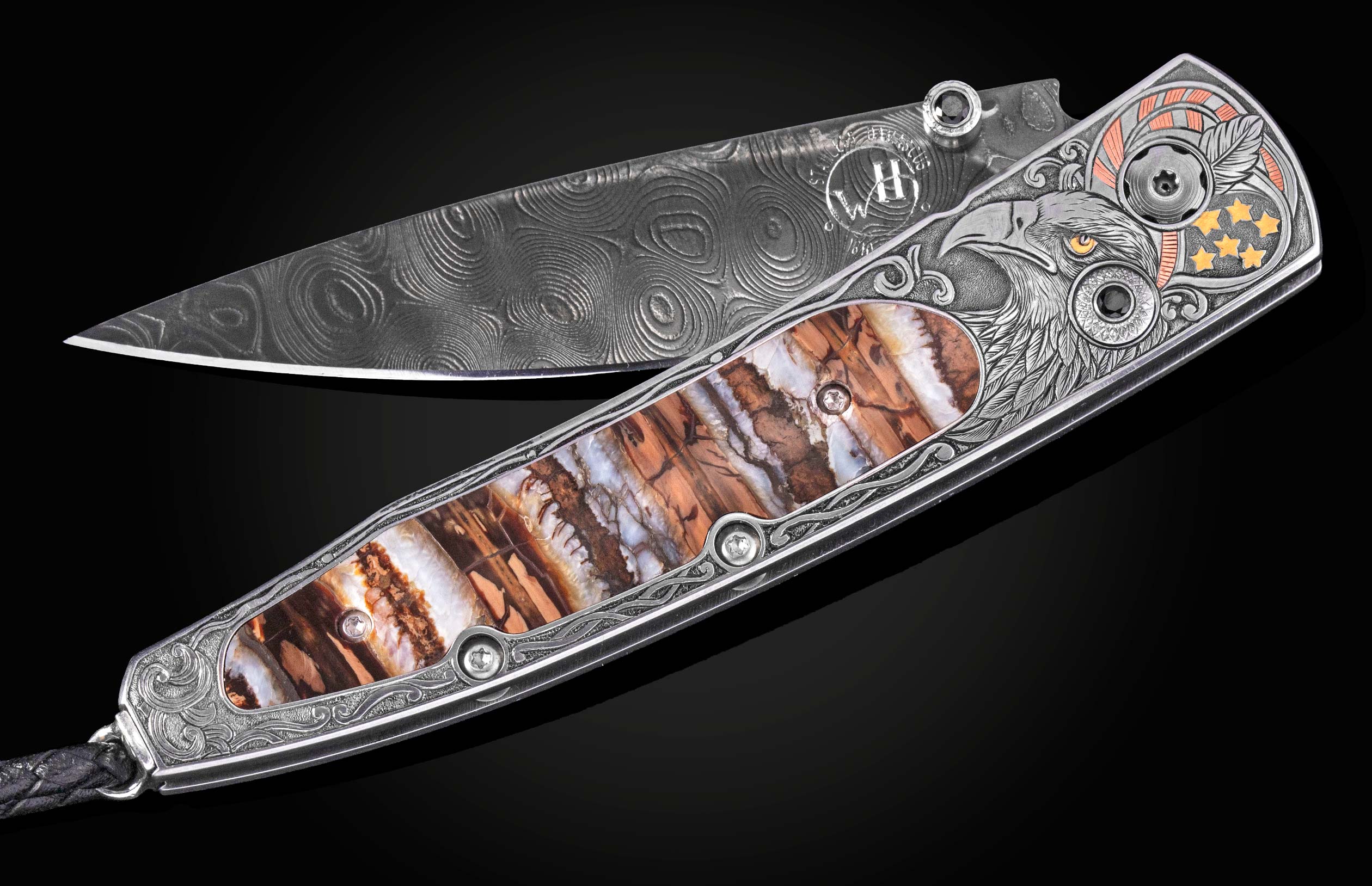 Damascus steel folding knife by B10 with engraved eagle head, amber inlay, and ornate silver handle, side view on black background