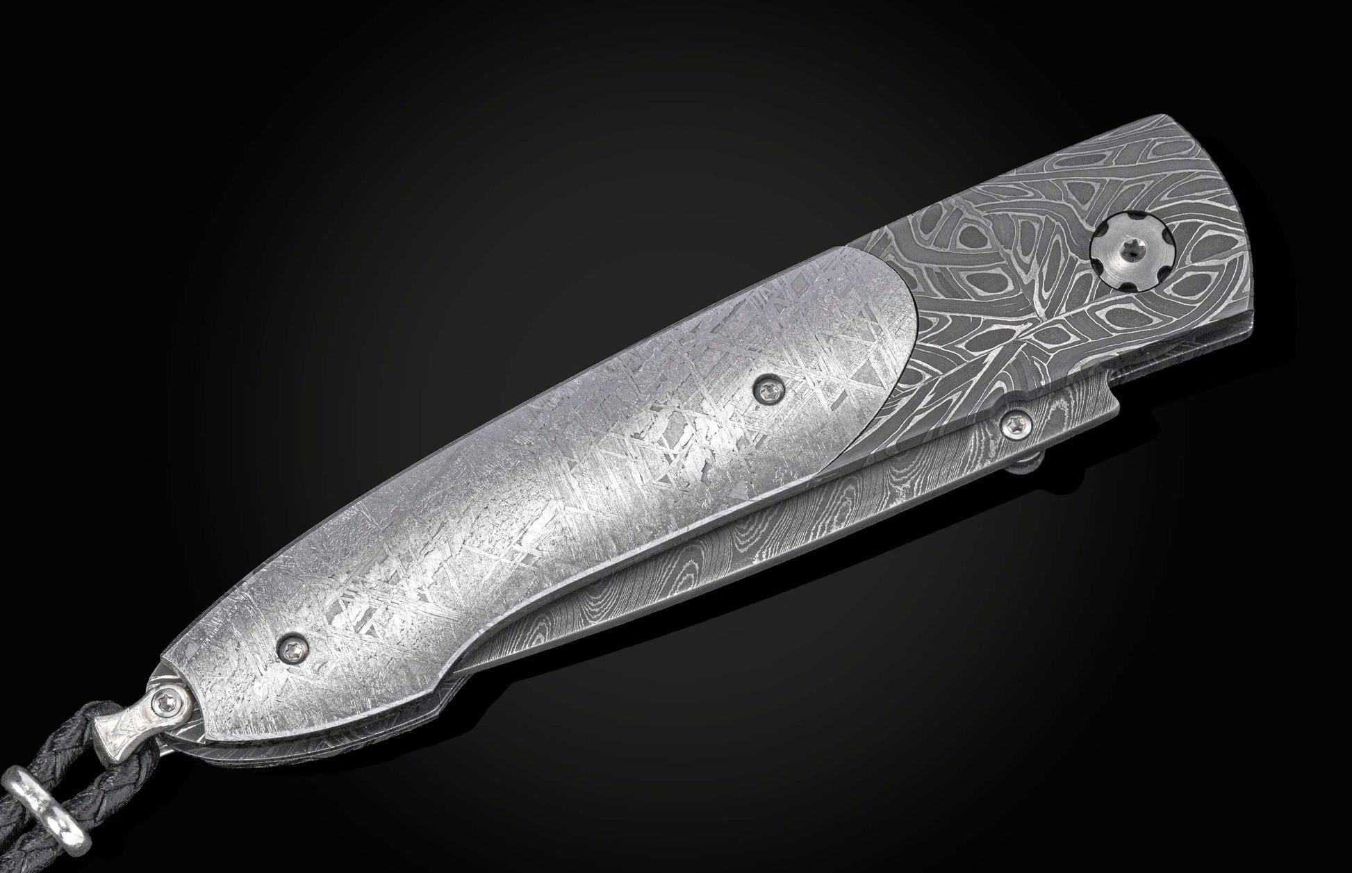 Decorative knife with damascus blade and meteorite handle on a black background shown closed