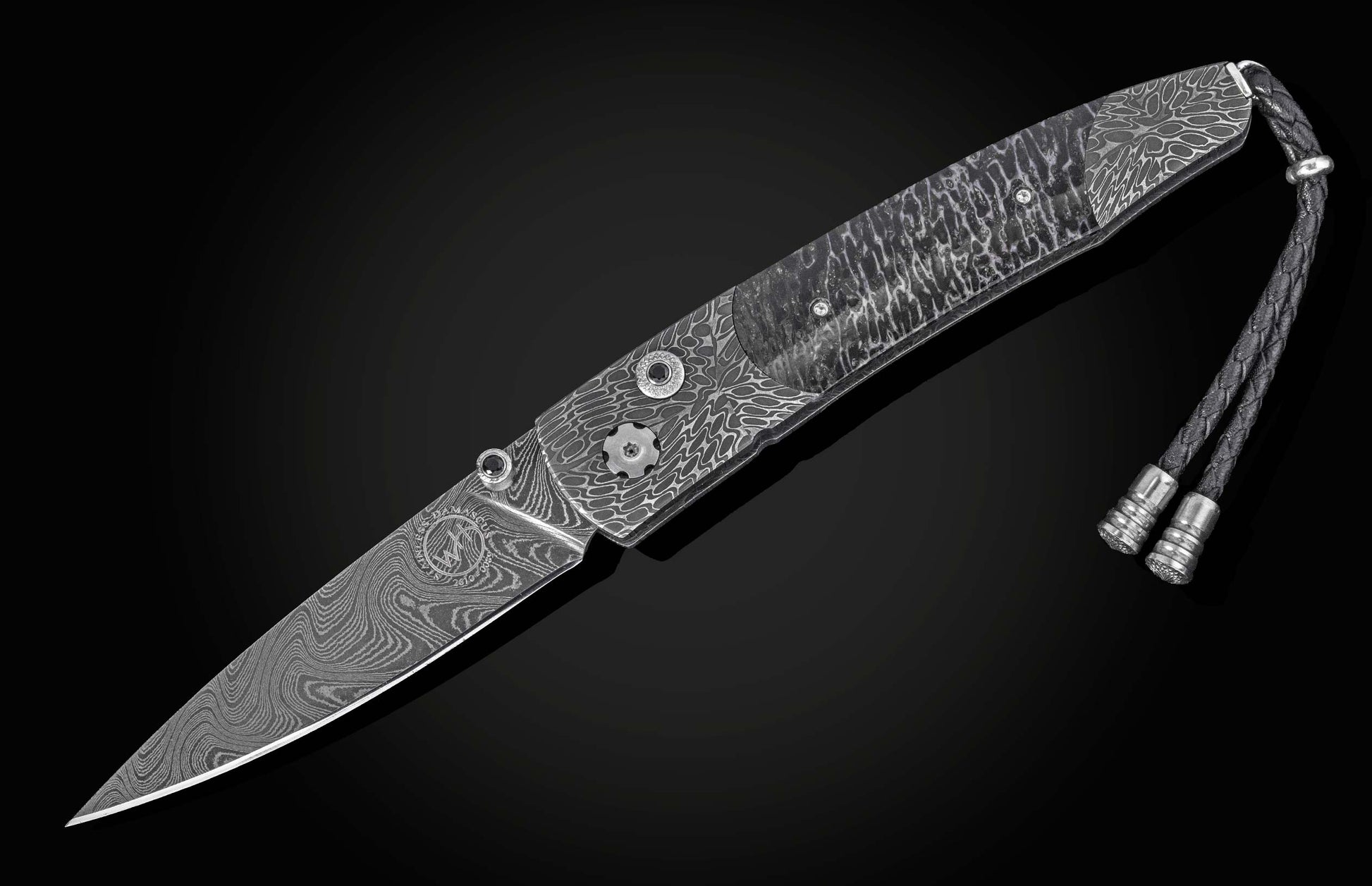 Damascus steel folding knife with wave pattern and braided lanyard, by B10, side view on black background