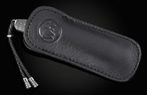 Black leather knife sheath with embossed logo and braided cord, by Mammuthus, featuring stitched edges and textured surface, side view.