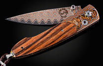 William Henry knife with zebra wood handle and damascus steel blade on a black background