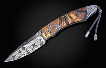Foldable knife with fossil mammoth tusk, hand engraving, and damascus blade on a black background