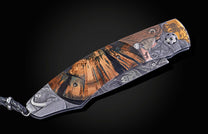 Foldable knife with fossil mammoth tusk, hand engraving, and damascus blade on a black background