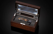 Foldable knife with fossil mammoth tusk, hand engraving, and damascus blade on a black background