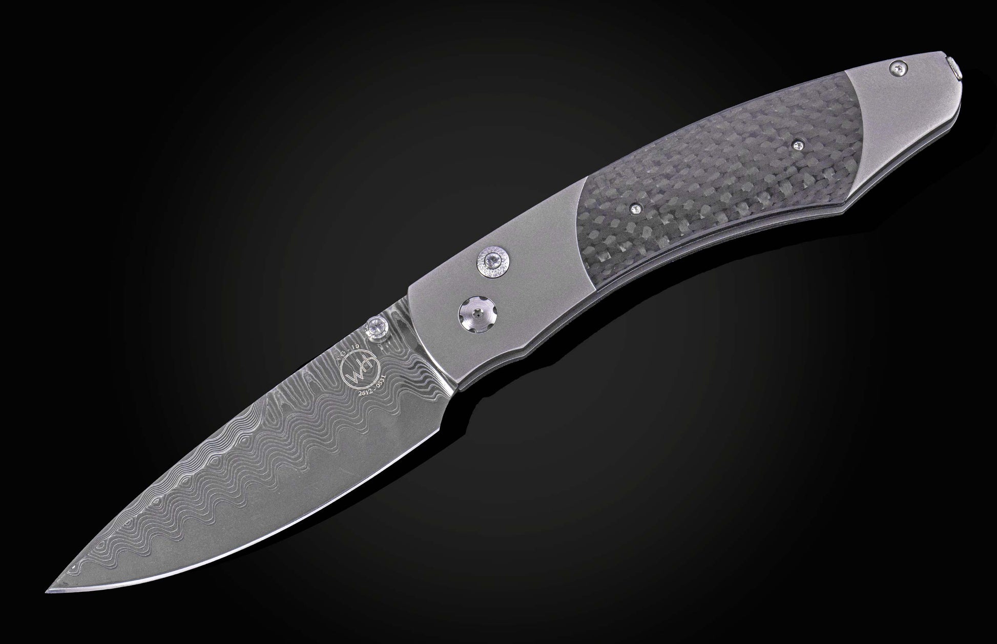 Titanium folding knife with dark carbon fiber inlay and a patterned Damascus steel blade.
