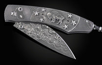 William Henry folding knife with damascus steel and hand carved sterling silver buffalo design