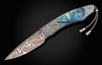 Damascus folding knife with blue stabilized wood handle, engraved metal accents, and a braided black leather lanyard.