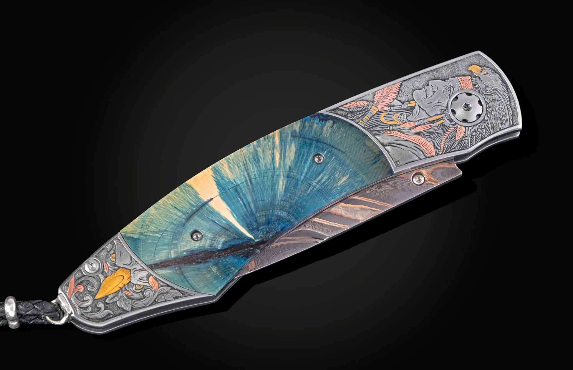 Ornate folding knife with a blue spalted wood handle, intricate silver-toned engravings of a chieftain and eagle with gold and copper accents, and a damascus blade.