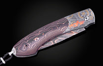 Hand engraved knife with Damascus steel blade on a black background