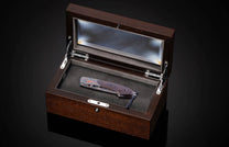 Hand engraved knife with Damascus steel blade on a black background