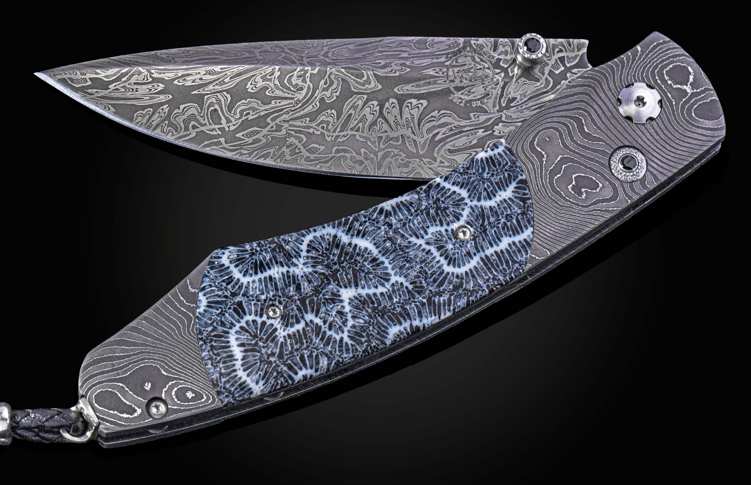 Folding knife with Damascus steel blade and fossil coral handle on a black background