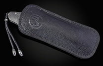 Folding knife with Damascus steel blade and fossil coral handle on a black background