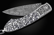 Damascus steel folding knife with black and white mosaic handle, gear accents, and chain detailing by B12, side view on black background