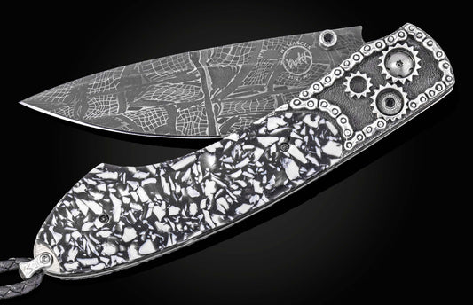 Damascus steel folding knife with black and white mosaic handle, gear accents, and chain detailing by B12, side view on black background