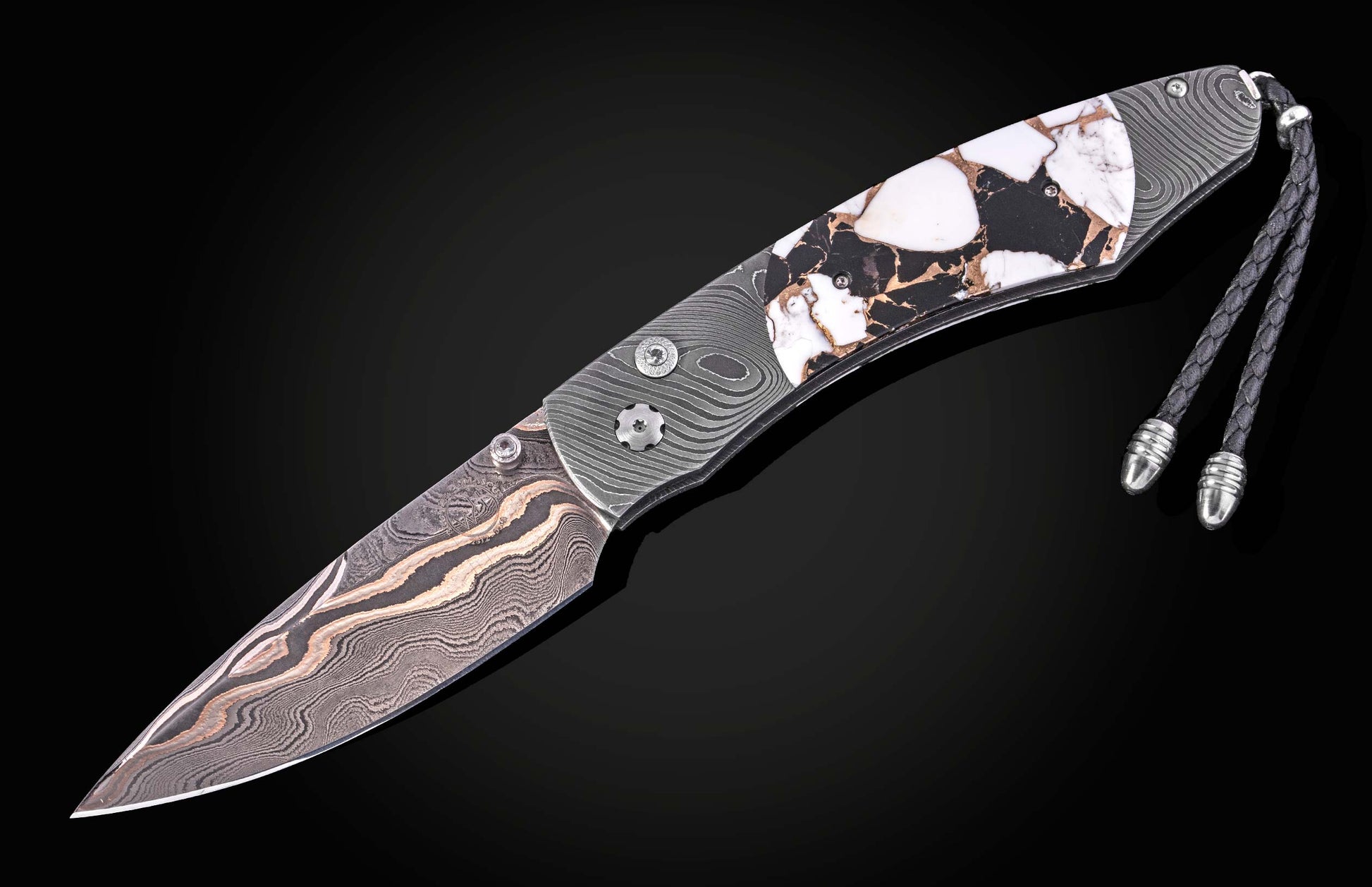 Damascus steel knife with white and black stone inlay handle by B12, featuring braided cord lanyard and wave-pattern blade, side view on black background