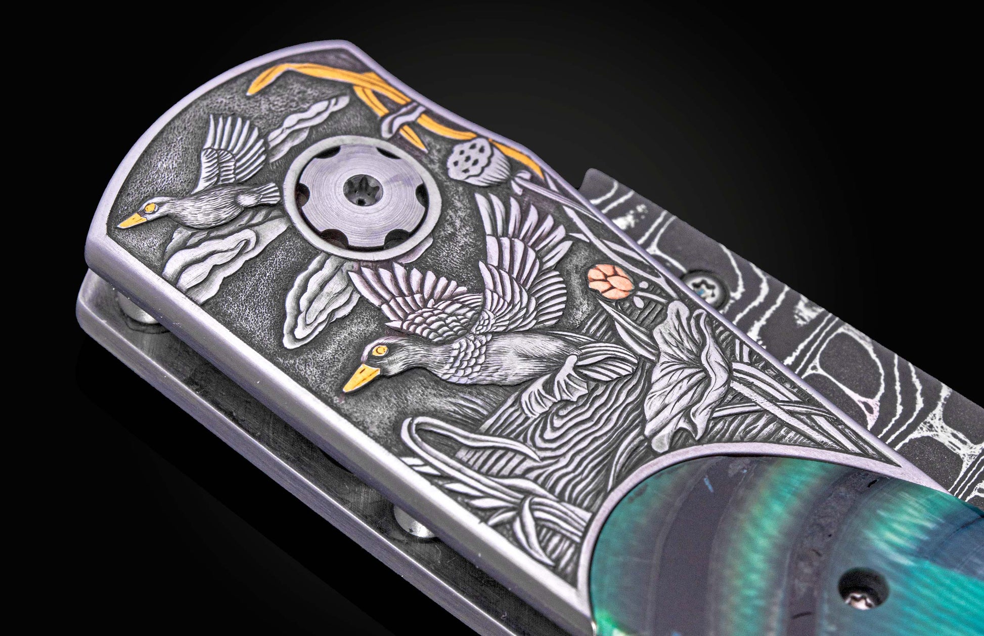 Hand engraved William Henry knife with mammoth tusk handle and damascus blade on a dark background