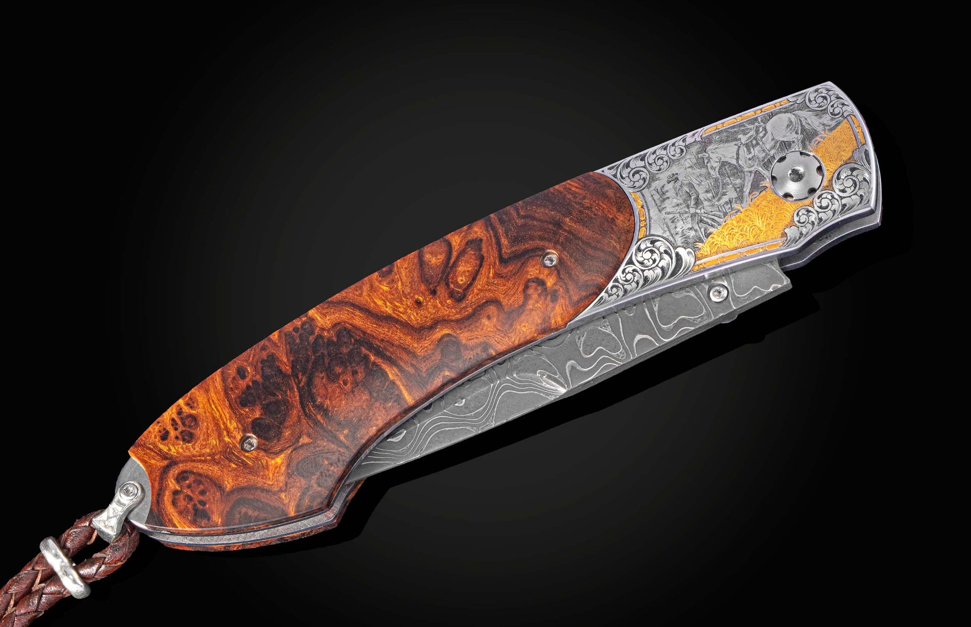 Custom folding knife with a burl wood handle and engraved silver bolster featuring gold accents and a Damascus steel blade.