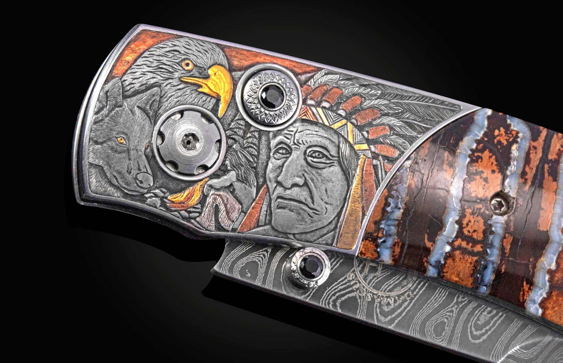 Ornate knife handle engraved with a Native American chief, eagle, and wolf, featuring black gems, a damascus blade, and patterned stone accents.