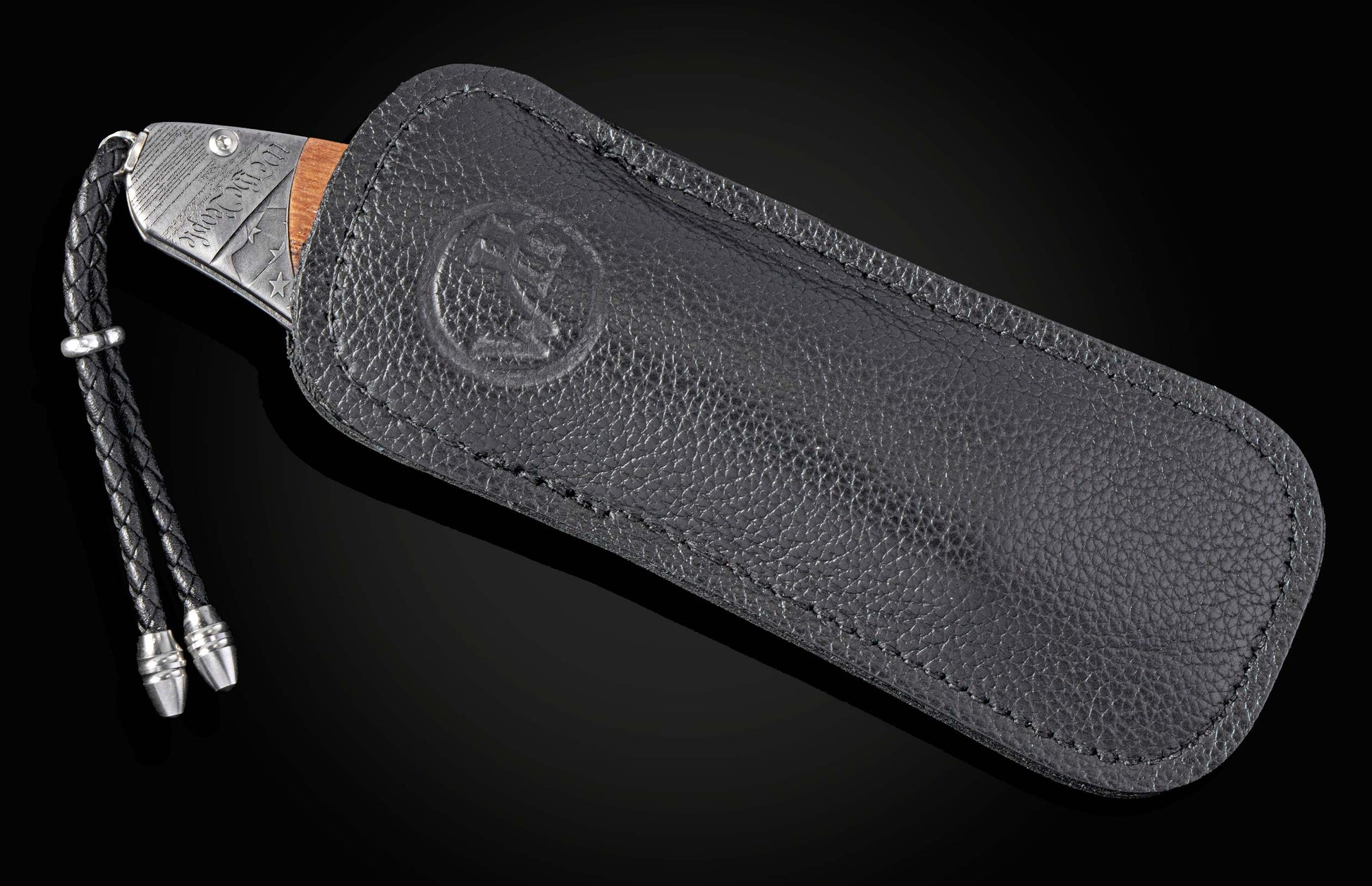 Silver knife with 'We the People' etching, wooden handle, in a black leather sheath with an embossed logo and braided lanyard.