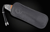 Silver knife with 'We the People' etching, wooden handle, in a black leather sheath with an embossed logo and braided lanyard.