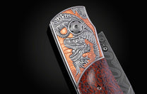 A custom folding knife with a silver dragon engraving on a copper plate, a dark red dinosaur bone scale, and a Damascus steel blade.