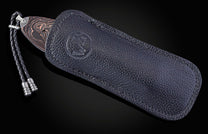 Folding knife with Damascus steel blade and hand engravings on a black background
