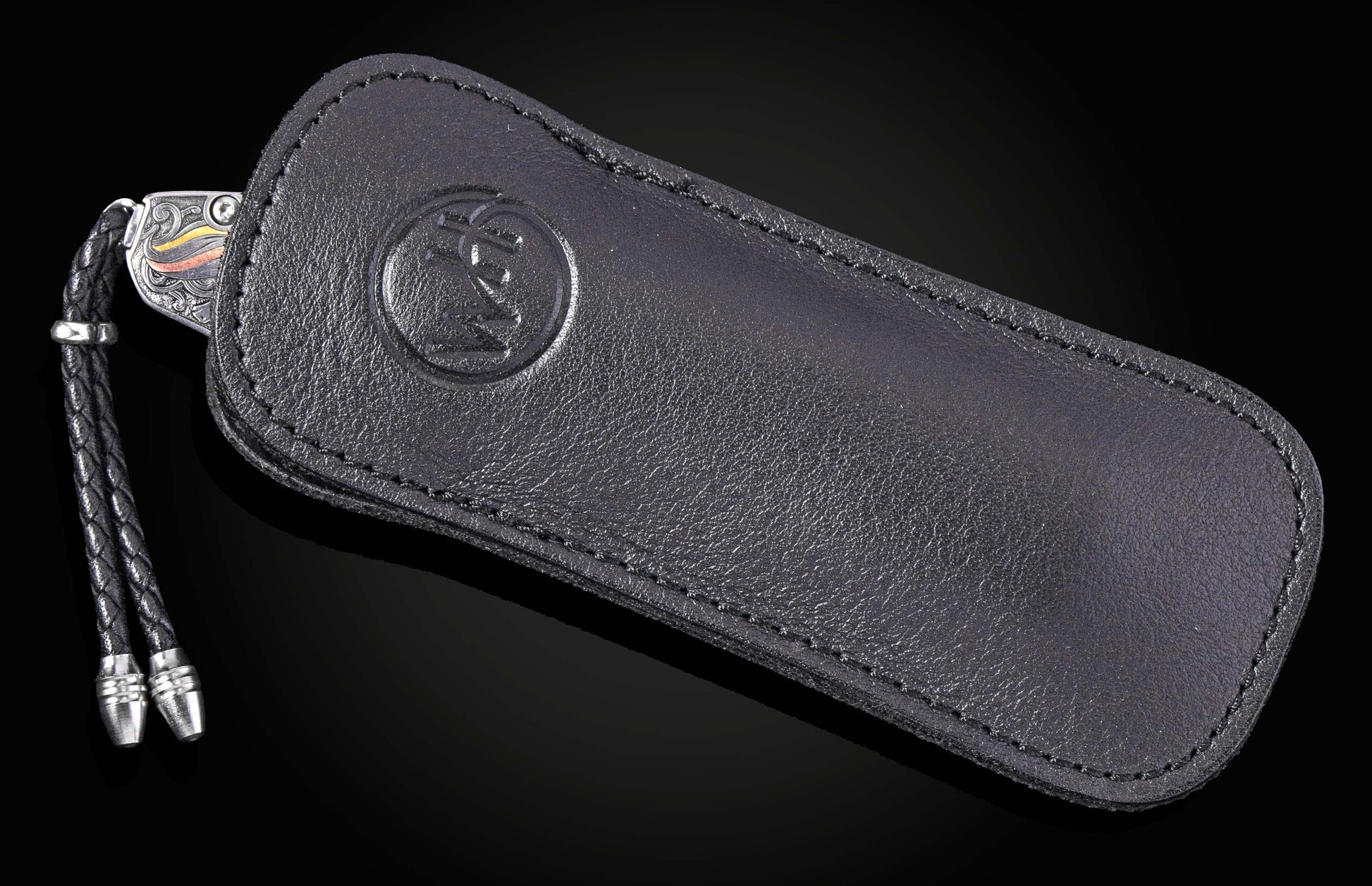 Black leather knife sheath with embossed logo and braided cord, by B12 NINE HORSES, side view on dark background