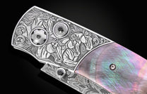Luxury folding knife with intricate nine horse engraving and mother-of-pearl inlay, by B12, featuring black gemstone accents and detailed scrollwork, side view.