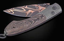 Folding knife with Damascus blade and black handle on a dark background