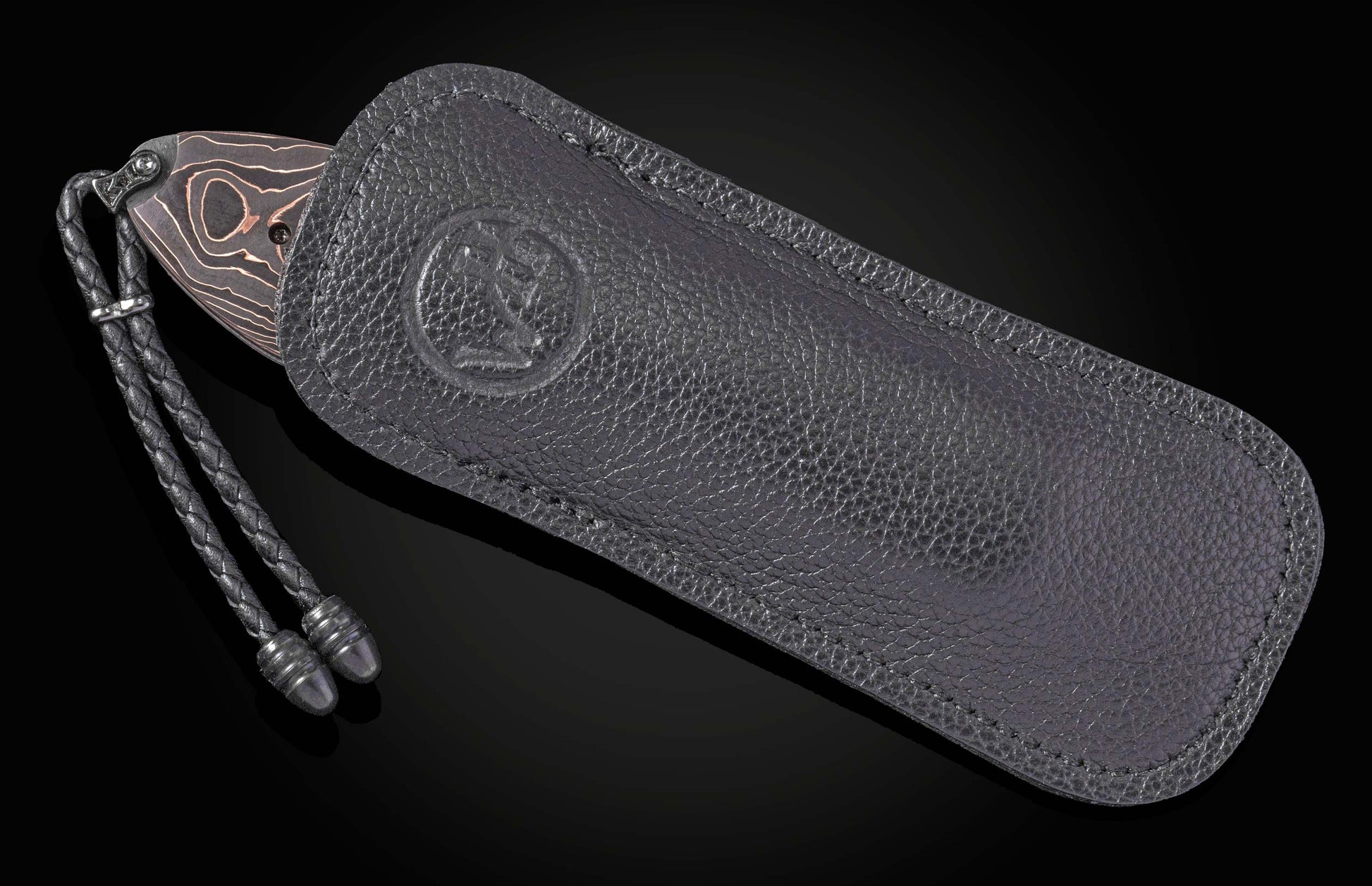 Folding knife with Damascus blade and black handle on a dark background