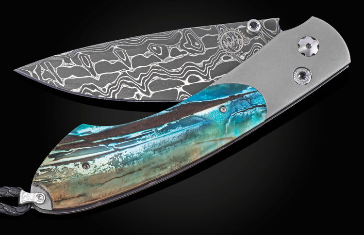 Damascus steel folding knife with wavy pattern and turquoise resin handle, side view on black background