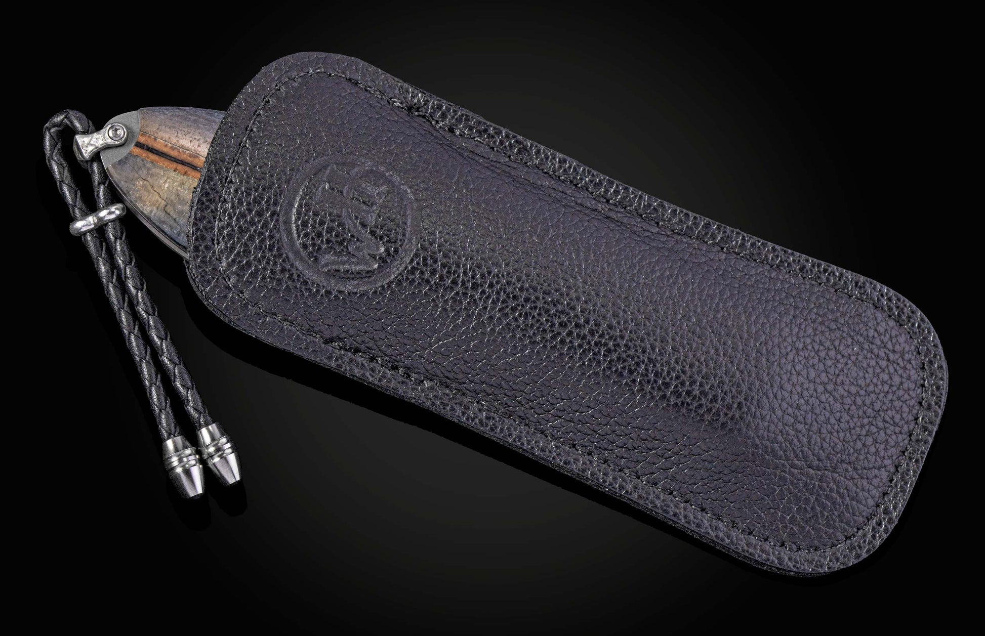 Folding knife with decorative blade and mammoth tooth handle on a black background