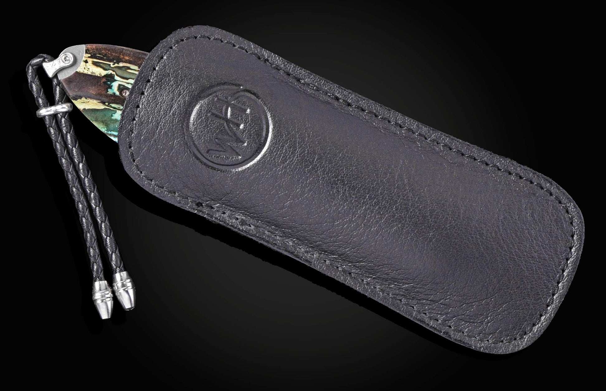 Black leather sheath with embossed logo and braided cord, holding B12 Parallel knife with marbled handle, side view