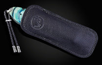 Black leather case with a William Henry knife on a dark background