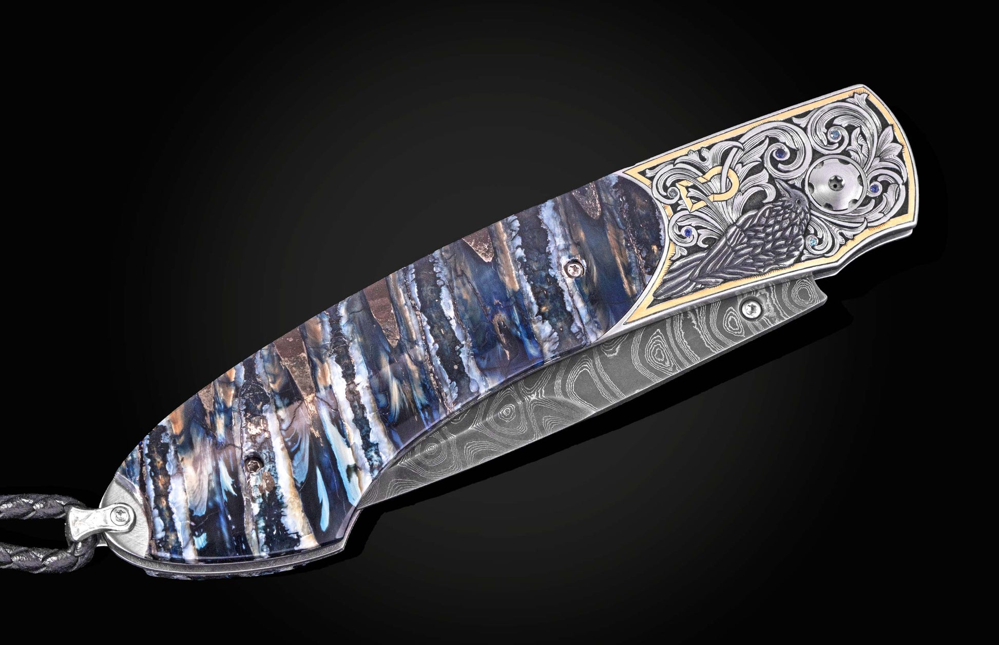 Luxury folding knife with blue marbled handle and damascus blade, featuring engraved raven motif and gemstone accents, side view on black background