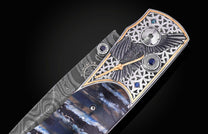Luxury Damascus steel knife with raven engraving, blue gemstones, and mother-of-pearl inlay, side view