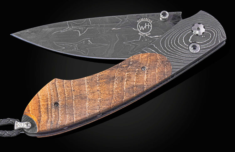 Folding knife with wooden handle and damascus blade on a black background